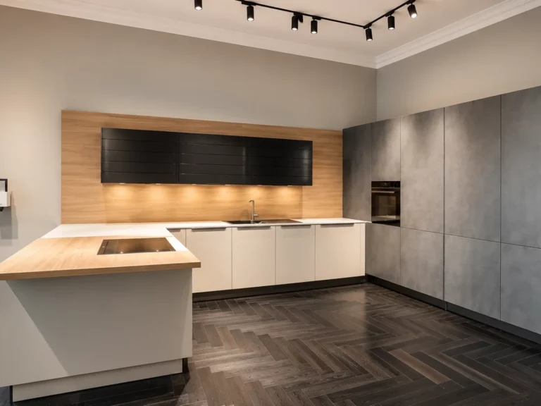 Cuisine Häcker contemporaine avec îlot central, crédence bois et colonnes gris ciment foncé Repro