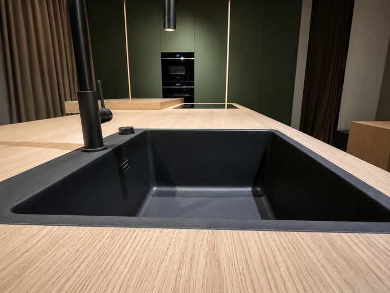 Plan de travail en bois clair avec plaque de cuisson et évier sur îlot central