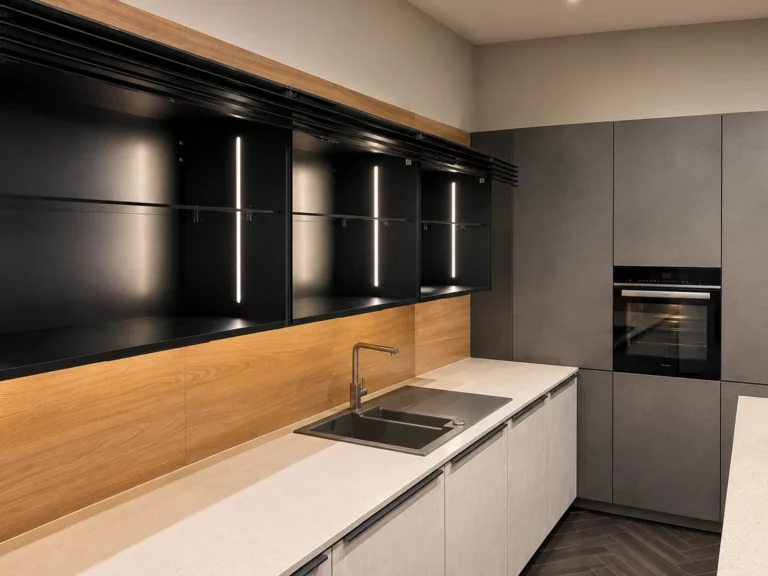Vitrine de cuisine noire éclairée avec façades ciment foncé Repro et crédence bois